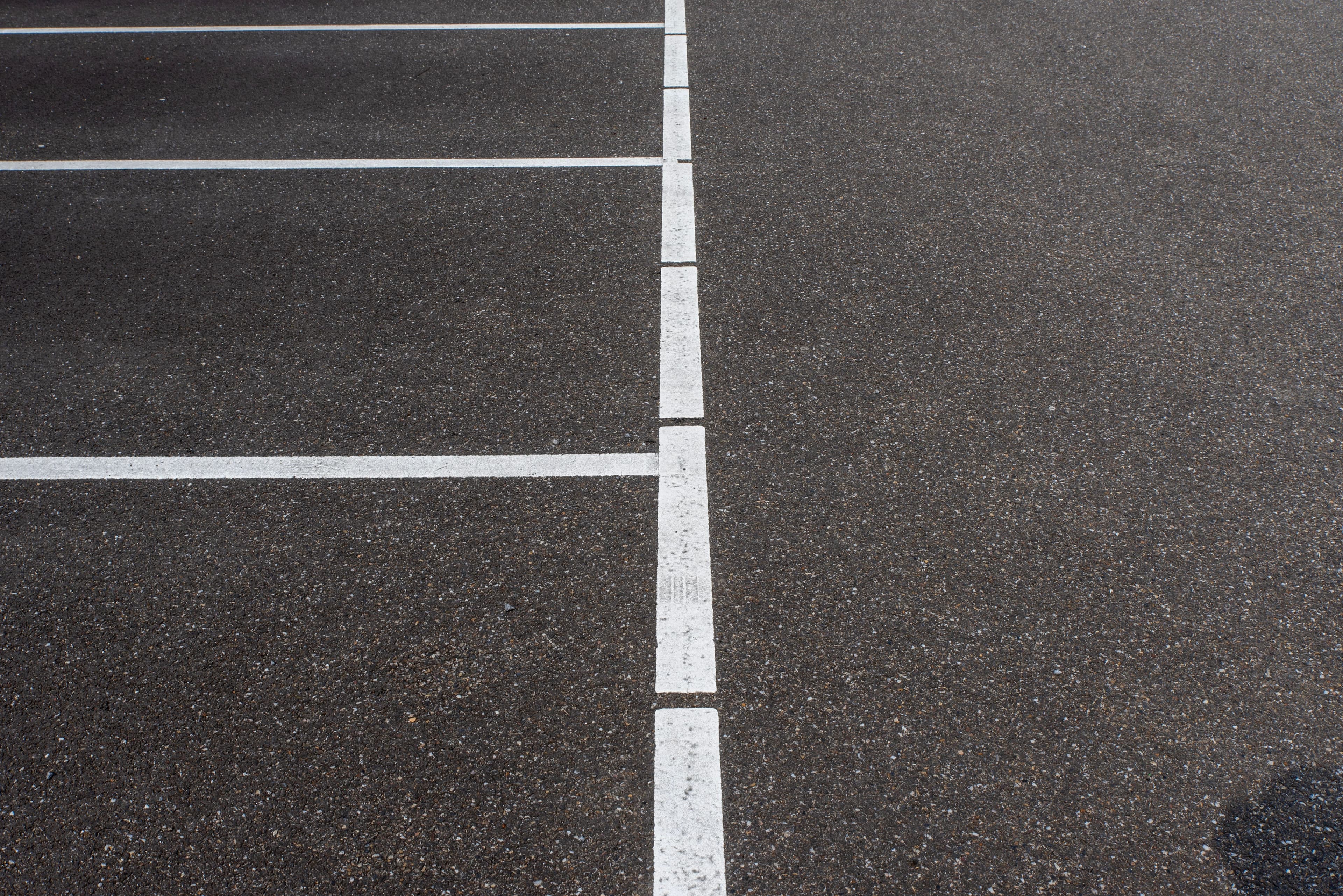 Freshly painted parking stall lines on asphalt
